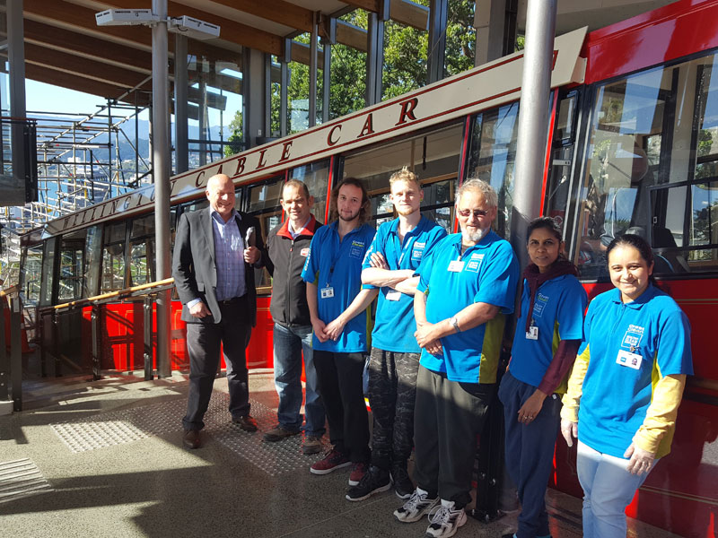 With a good job done for another day, Crest teams take a chance to pose against the background of one of the revamped cable cars. With them are Richard Brodie (CrestClean Wellington Regional Manager), and Matthew Hardy (Passenger Service Manager).