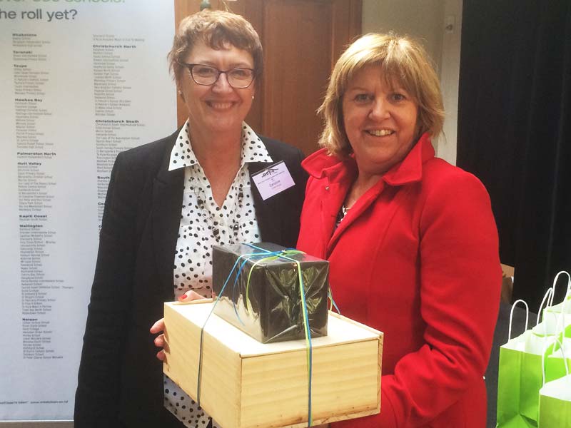 Liz Walker, Principal at St Leo's School, Devonport, receives a gift hamper from Caroline Wedding (left), Auckland North Shore Regional Manager.