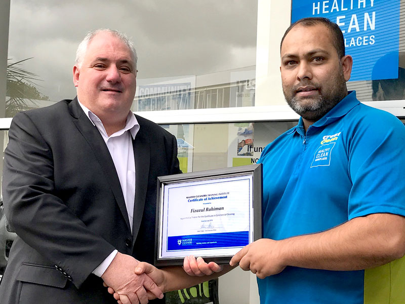 Fiza Rahiman receives a Certificate of Achievement from the Master Cleaners Training Institute. Making the presentation is Dries Mangnus, CrestClean’s Auckland Central Regional Manager.