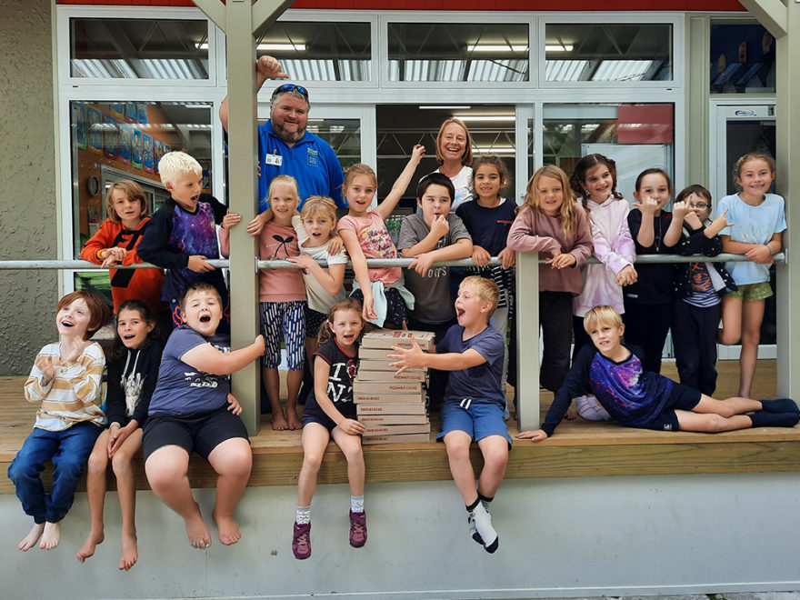 Students celebrate award with pizza.