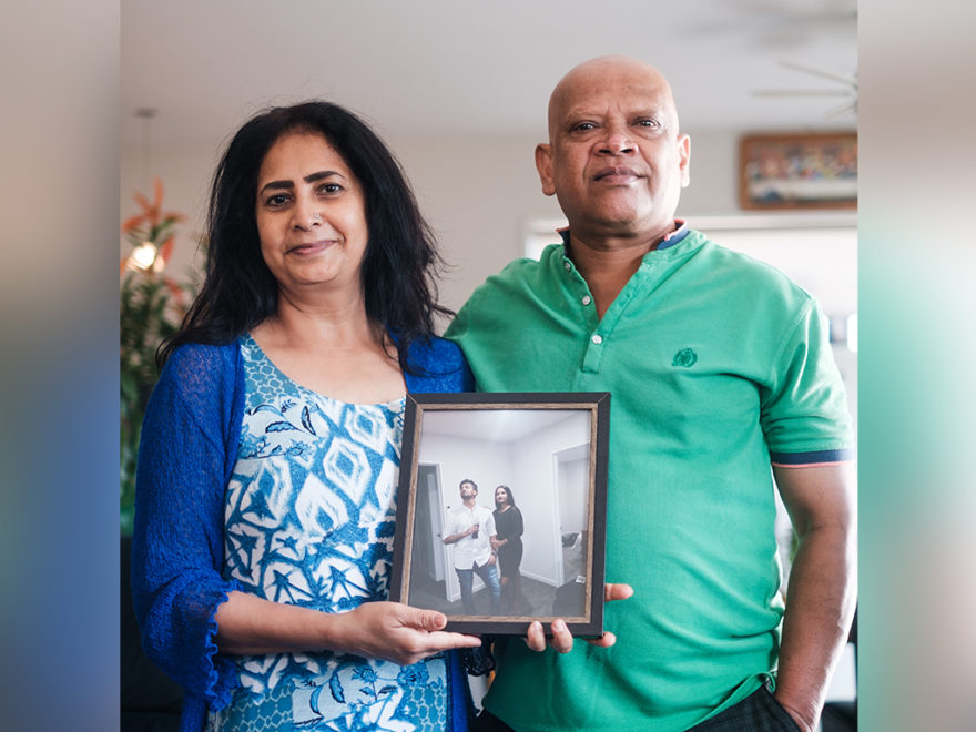 Couple holding photo of their children.