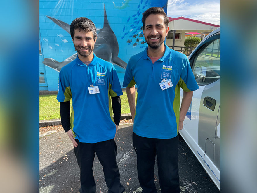 Brothers who are cleaners standing by their van.