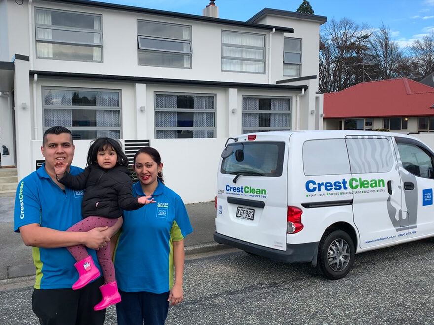 Cleaners standing in front of their new house.