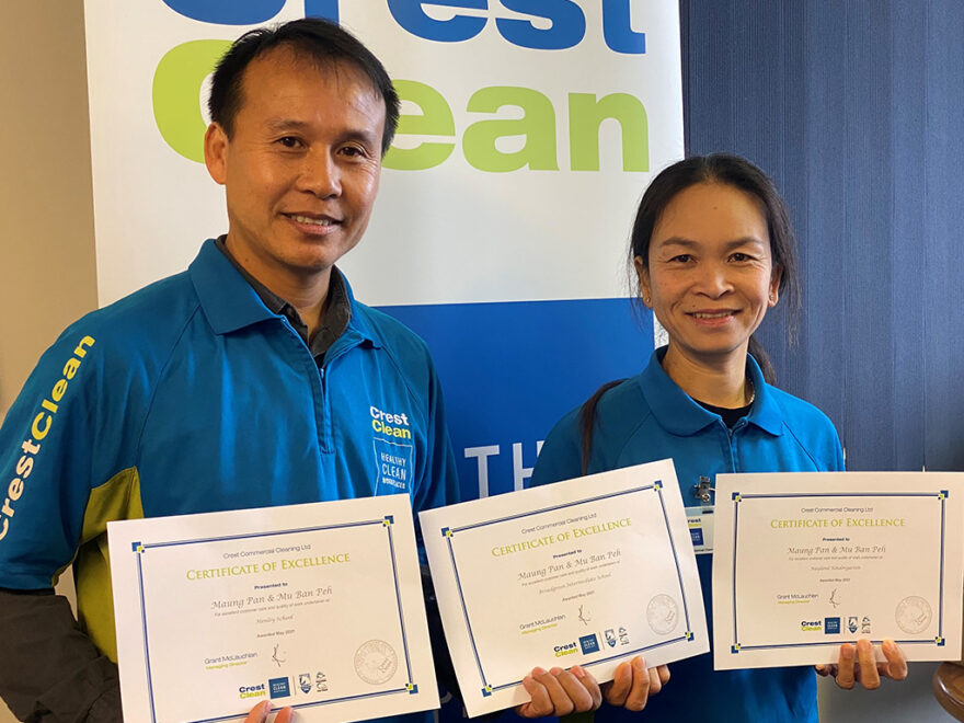 Cleaners proudly holding certificates.