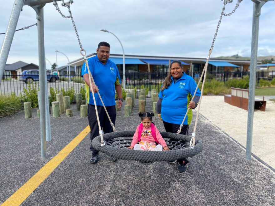 Parents at the park with their daughter.