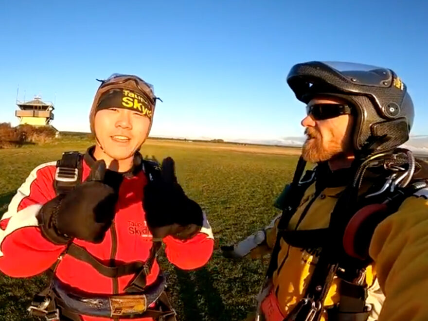 Man giving thumbs up after skydive.