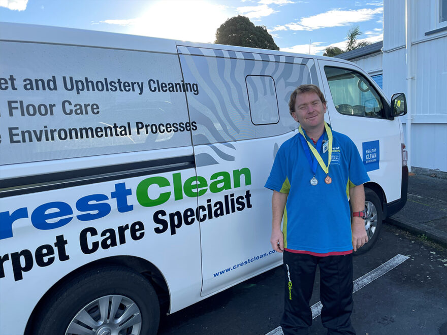 Cleaner wearing sports medals around his neck.