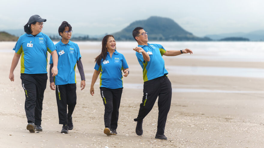 Family of cleaners walking on the beach.