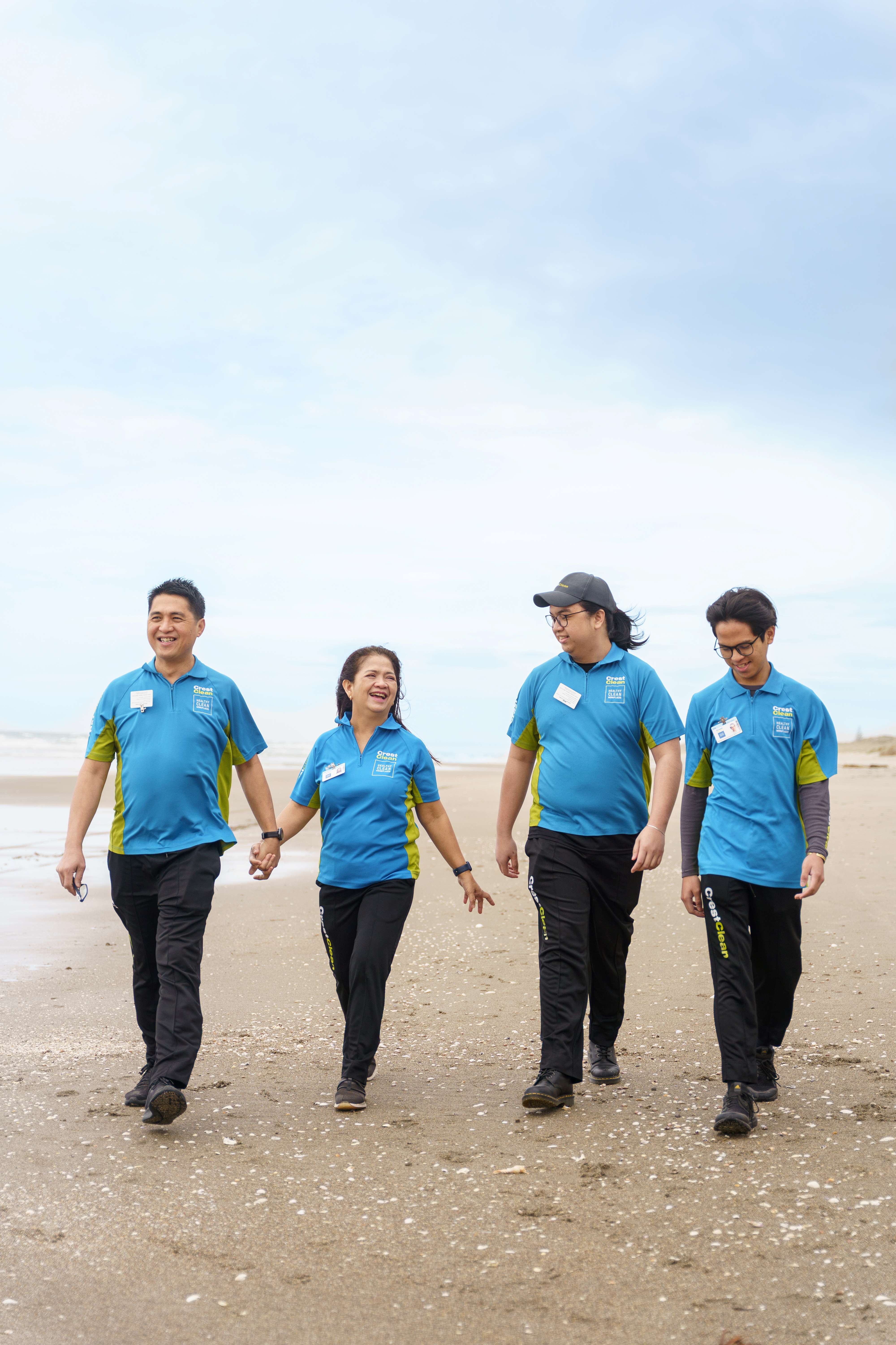 Family of cleaners walking on the beach.