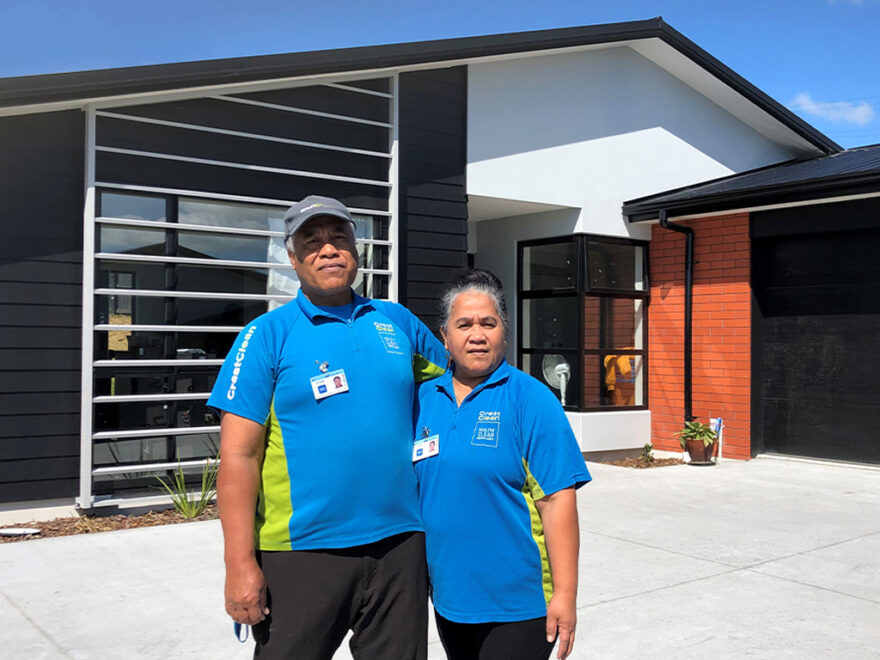 Cleaners standing outside their new home.