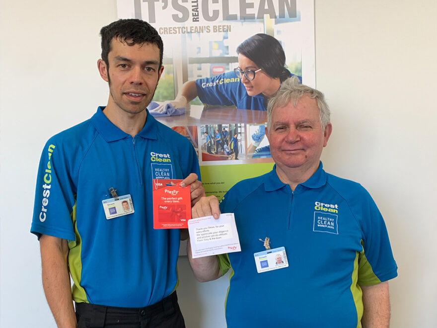 Cleaners holding up gift cards.