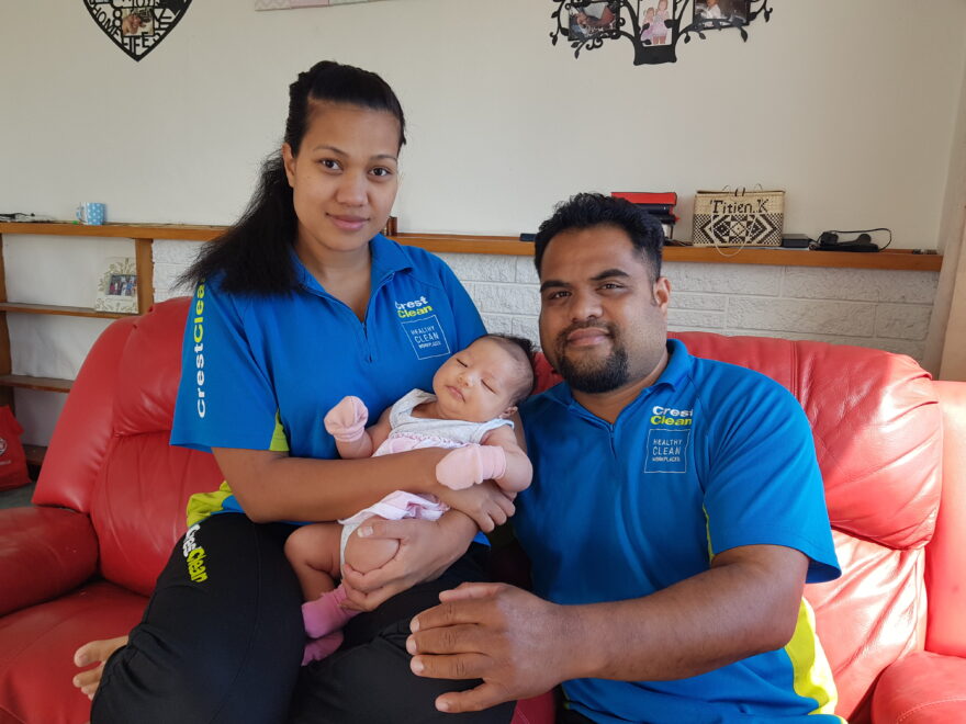 Cleaning couple holding baby girl.