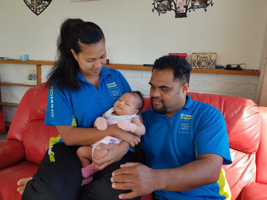 Cleaning couple holding baby girl.