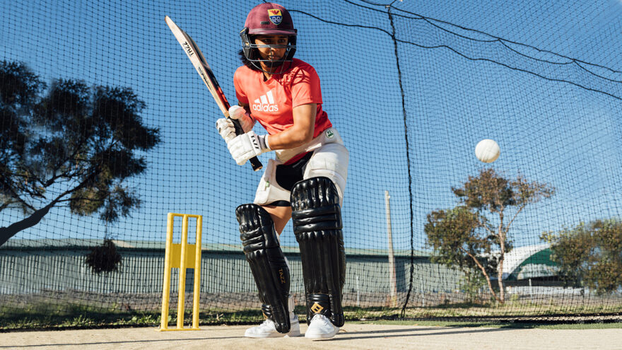 Female cricketer batting.