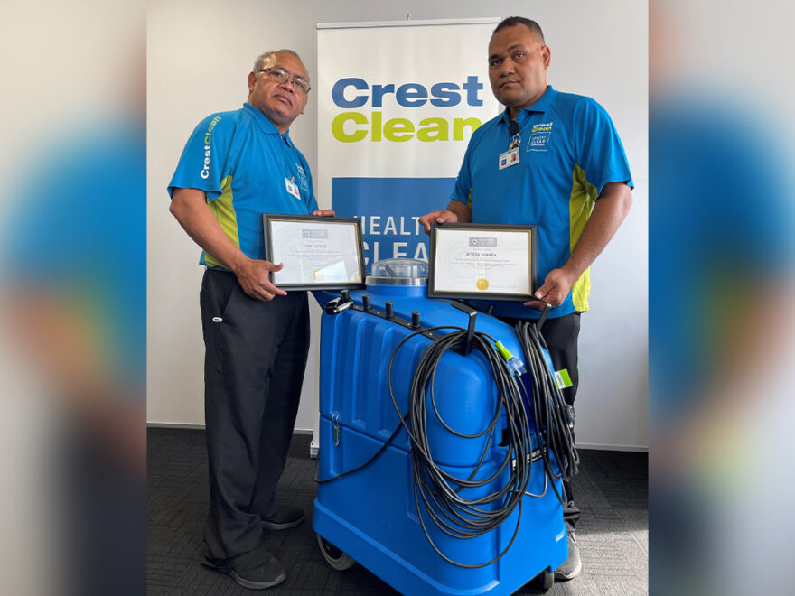 Two cleaners standing with a carpet machine.