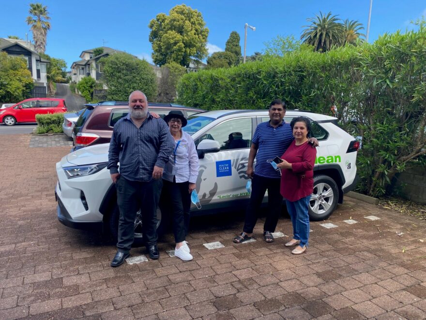 Group of people standing by a branded cleaning vehicle.