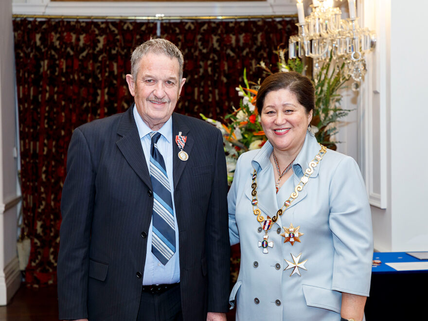 Man wearing medal standing next to Governor General.