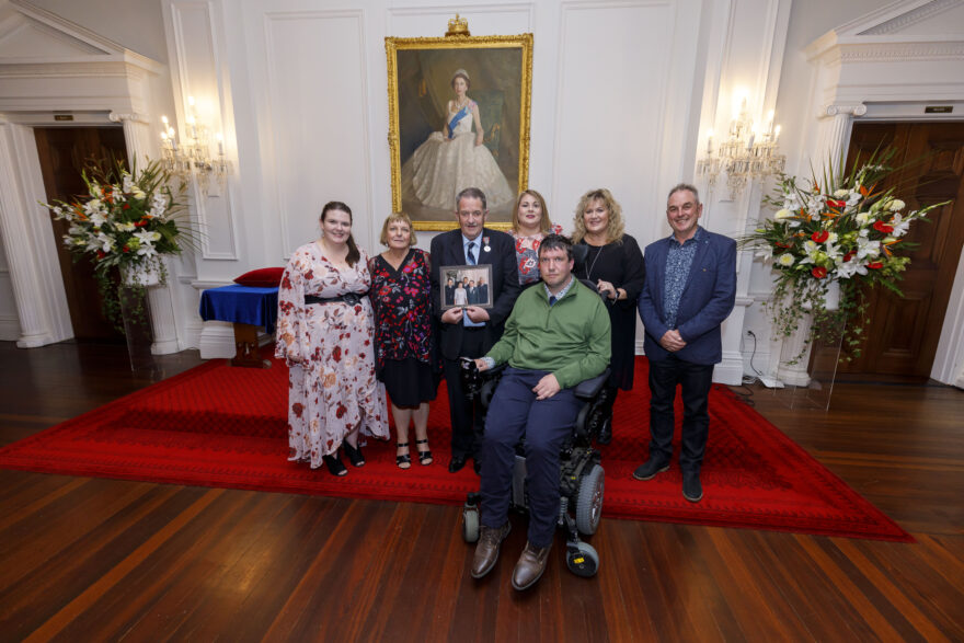 Man standing with his family at ceremony.